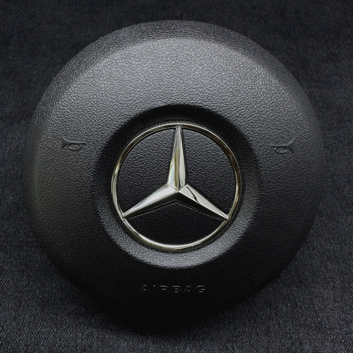 A black Mercedes-Benz branded steering wheel airbag