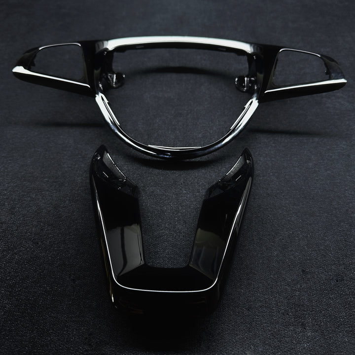 A pair of black piano-style steering wheel trims for a Mercedes-Benz vehicle