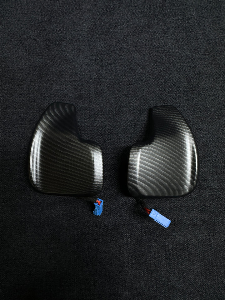 A pair of matte carbon style shift paddles for a BMW