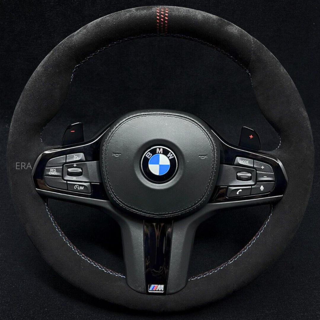 A black BMW steering wheel with red stitching, white stitching, and black trim. The steering wheel features the BMW logo at the center and ERA branding on the bottom.
