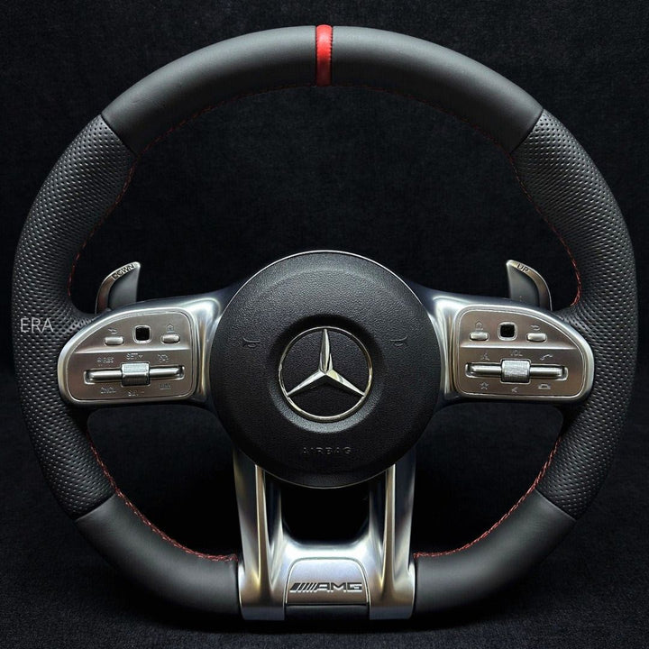 Customized steering wheel with red stitching, black leather, and shift paddles, featuring a carbon fiber and metal finish