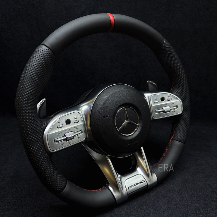 Customized steering wheel with red stitching, black leather, and shift paddles, featuring a carbon fiber and metal finish.