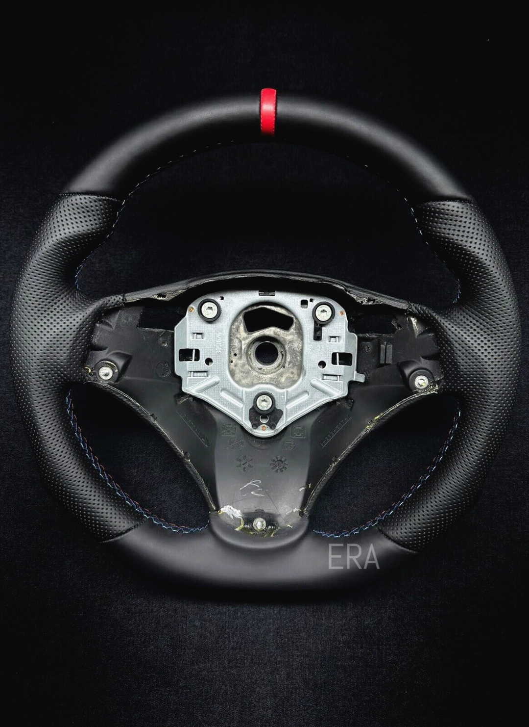  black perforated leather steering wheel with a red stripe and M stitching, designed for BMW vehicles