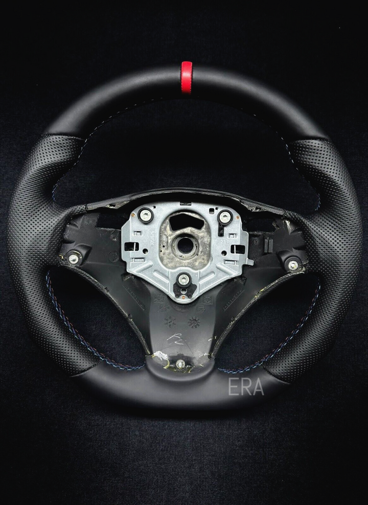  black perforated leather steering wheel with a red stripe and M stitching, designed for BMW vehicles