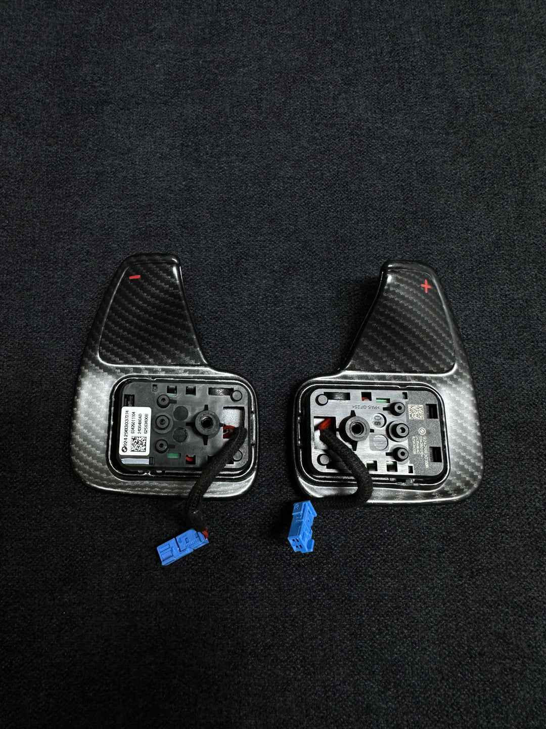 A pair of matte carbon style shift paddles for a BMW vehicle