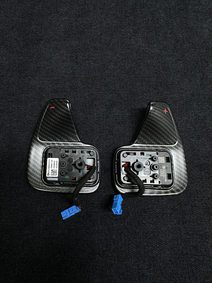 A pair of matte carbon style shift paddles for a BMW vehicle